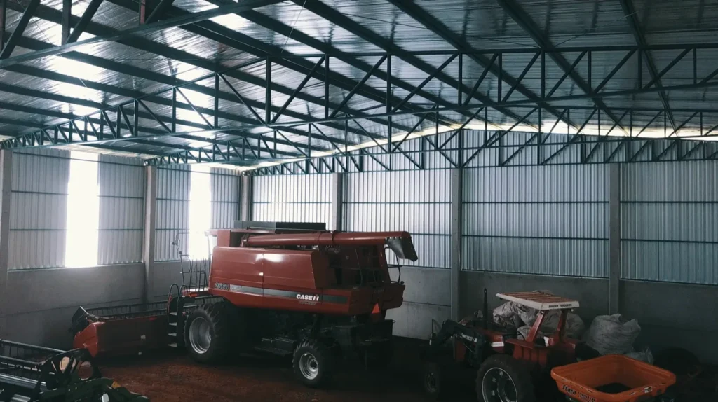 Barracão agrícola abrigando colheitadeira e maquinário pesado