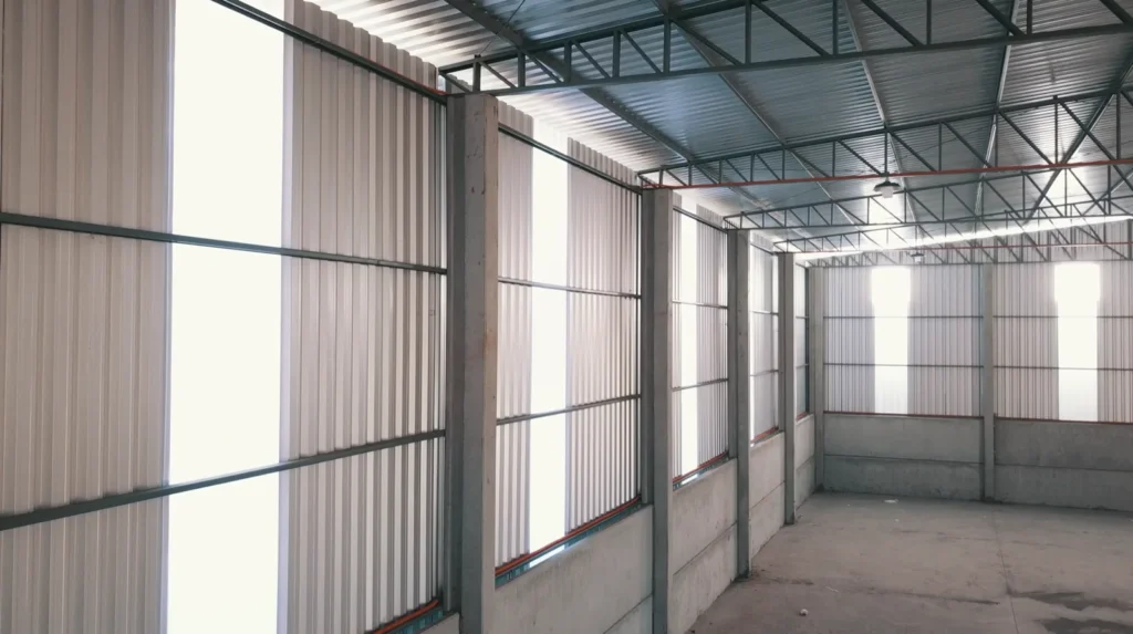 Barracão em obra com fechamento metálico e pilares pré-moldados
