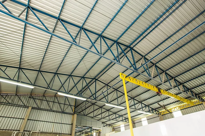 Interior de barracão industrial com estrutura metálica e viga de ponte rolante